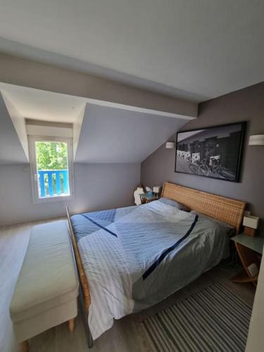 um quarto com uma cama grande e uma janela em Charmante maison proche de Paris em Sainte-Geneviève-des-Bois