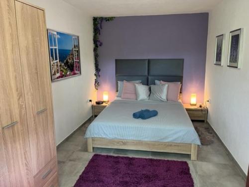 a bedroom with a large bed with purple walls at Apartment Ines in Splitska