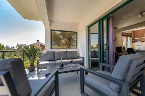 a living room with a couch and chairs on a balcony at Apartments Triporte in Vela Luka