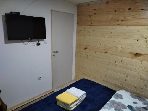 Habitación con cama y TV en la pared. en Milica 2 en Crni Vrh