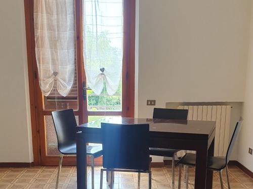 a dining room with a table and chairs and a window at Latte e Menta in Lamporecchio