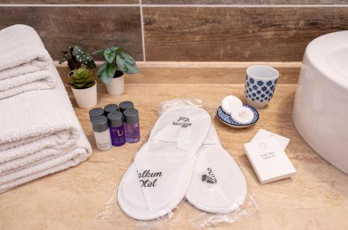 a bathroom with a pair of white shoes and towels at Salkım Otel Gökçeada in Gokceada Town