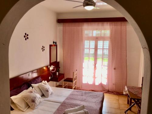 Un dormitorio con una cama grande y una ventana en Dionysos Studios, en Laganas