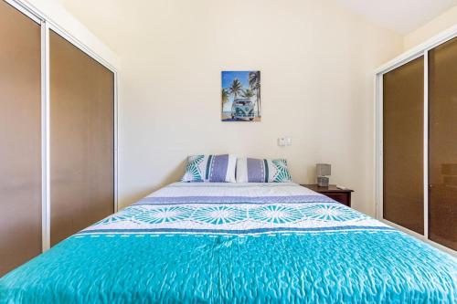 a bedroom with a bed with a blue comforter at Paramount Views in San Felipe de Puerto Plata