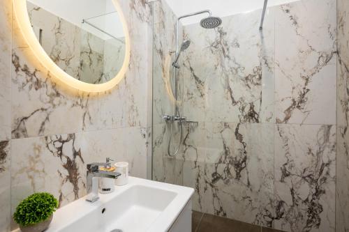 een badkamer met een wastafel en een douche met een spiegel bij Boutique LUX Rooms Odello Split Old Town in Split