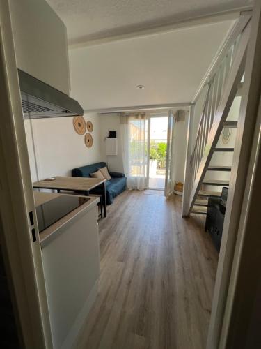 a room with a staircase and a living room at Petite maison de vacances au bord de l'eau in Leucate