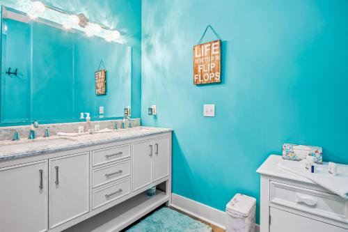 a blue bathroom with two sinks and a mirror at Windy Lane Leisure in Pawleys Island