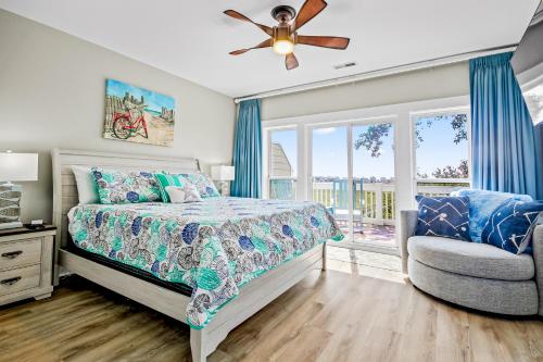a bedroom with a bed and a chair and a window at Windy Lane Leisure in Pawleys Island