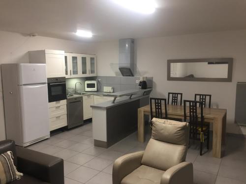Il comprend une cuisine équipée d'un réfrigérateur blanc, d'une table et de chaises. dans l'établissement Maison Lore Mendi Amotz, à Saint-Pée-sur-Nivelle