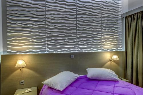 a bedroom with a purple bed with two pillows at Ethrion in Ermoupoli