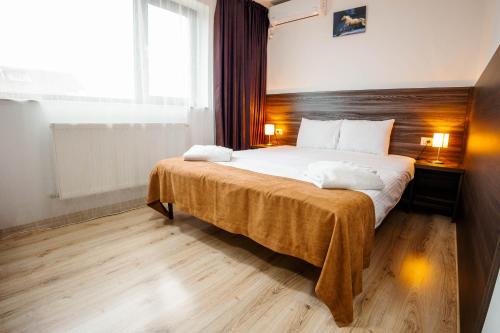 a bedroom with a large bed with a wooden headboard at Bliss Inn Tunari in Tunari