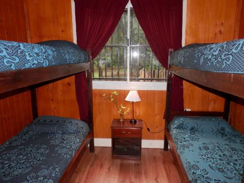 two bunk beds in a room with a window at Cabañas Los Timbó in Ituzaingó