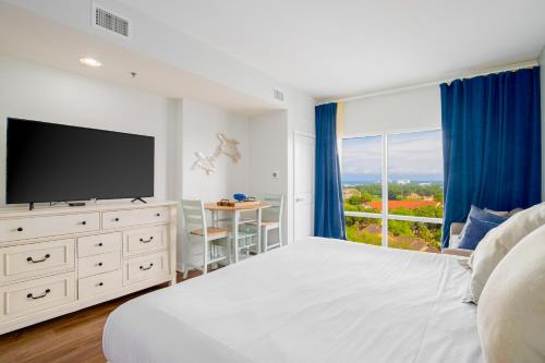 a white bedroom with a large bed and a large window at Luau 7012 in Destin