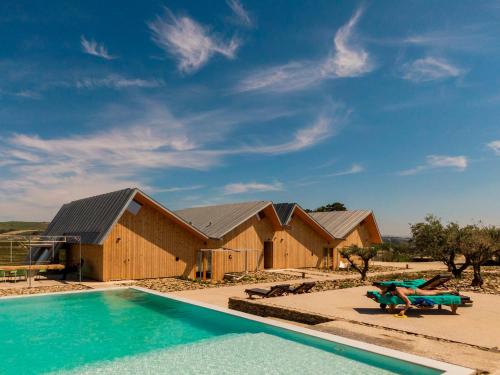 a row of wooden buildings with a swimming pool at QUINTA DA FAÍSCA - Agro Turismo in Favaios