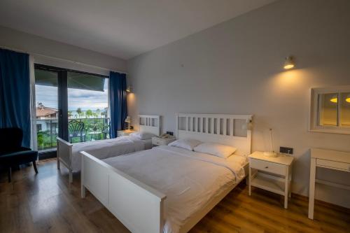 a bedroom with a large white bed and a window at Eleia Hotel İznik in Bursa