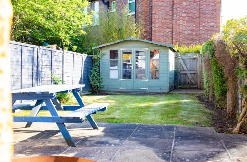 a blue picnic table in a yard with a house at Town Centre 4-bed House in Harrow