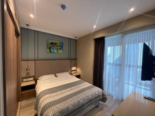a bedroom with a bed and a large window at Paradise Apartments Batumi in Batumi