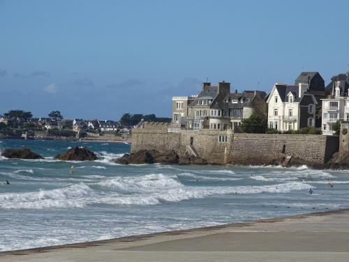 un groupe de personnes dans l'océan avec des maisons dans l'établissement Appartement Philomène, à Saint-Malo