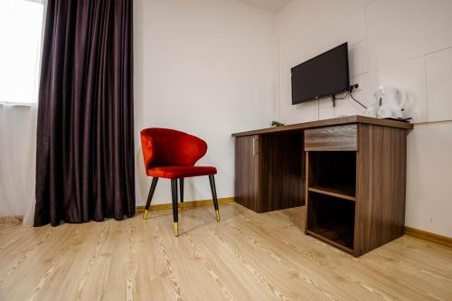 a living room with a red chair and a television at Bliss Inn Tunari in Tunari
