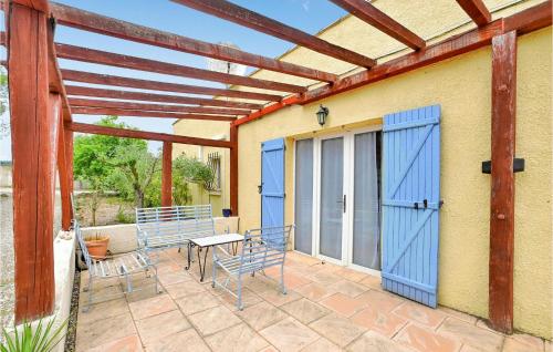 a patio with blue doors and chairs and a table at Lovely Home In Aspiran in Aspiran