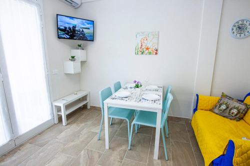 uma sala de jantar com uma mesa e cadeiras e um sofá em Casa Elda em Marina di Ragusa