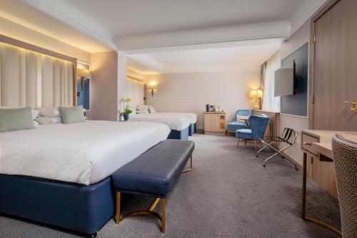 a hotel room with two beds and a desk at Danubius Hotel Regents Park in London