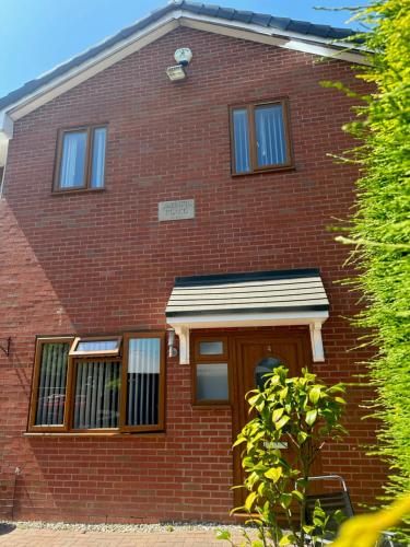 a red brick house with a brown door at Entire 2 bedroom house. in Rowley Regis