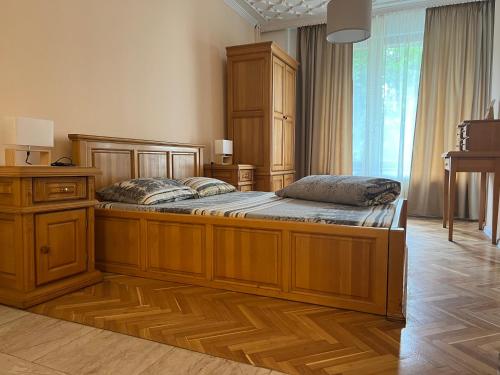 a bedroom with a large wooden bed with two pillows on it at Stivan Iskar Hotel in Sofia