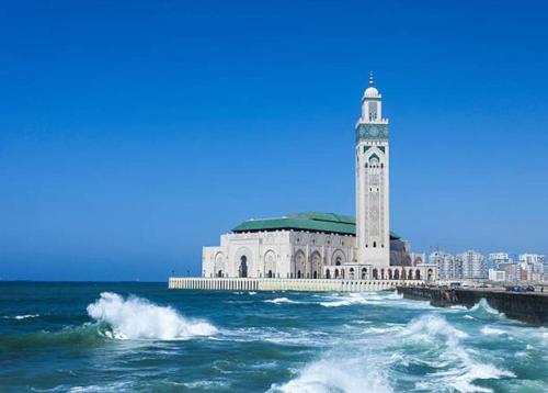 un edificio con una torre de reloj junto al océano en Best location, 2 minute to beach, en Casablanca