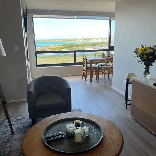 a living room with a table and a dining room with a view at Superb accommodation in Stilbaai in Stilbaai