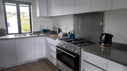 a kitchen with a stove top oven next to a sink at Superb accommodation in Stilbaai in Stilbaai