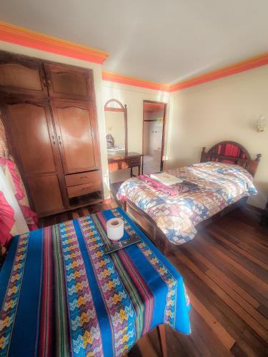 a hotel room with two beds and a table in it at Hotel Chasqui del Sol in Copacabana