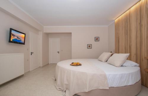 a bedroom with a large white bed with a white blanket at Kozanos Hotel & Suites in Amoudi