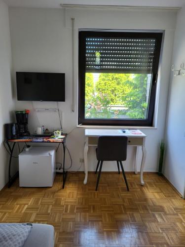 een kamer met een bureau en een raam met een computer bij Messe Flughafen in Düsseldorf