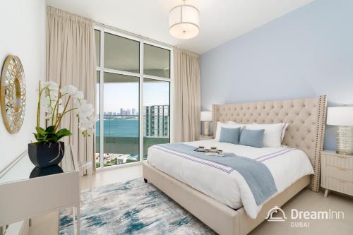 a bedroom with a bed and a large window at Dream Inn Apartments - Mina by Azizi in Dubai