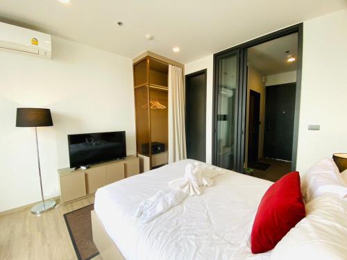 a white bed with red pillows in a bedroom at Edge Central Pattaya Vip Condo in Pattaya Central