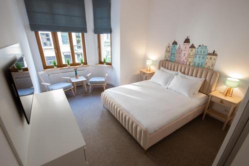 a bedroom with a white bed with a castle headboard at Apartament "Koty w mieście" Mostowa 27 in Toruń