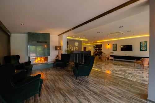 a lobby with a fireplace and chairs and a living room at Eleia Hotel İznik in Bursa