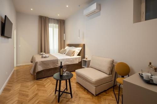 una camera d'albergo con letto e sedia di Boutique LUX Rooms Odello Split Old Town a Spalato (Split)