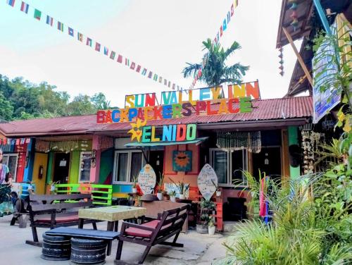 a colorful restaurant with tables and chairs in front of it at Sun Valley Hostel in El Nido