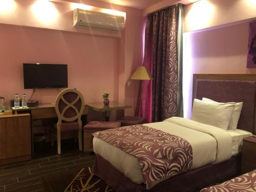 ein Hotelzimmer mit einem Bett und einem Schreibtisch in der Unterkunft Santana Hotel Cairo in Kairo