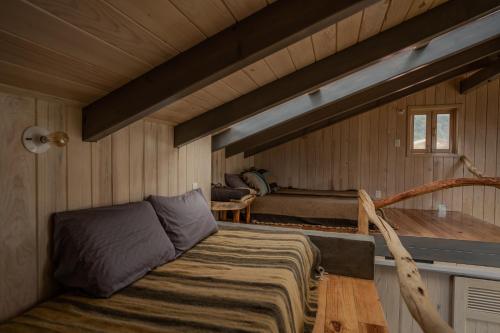 um quarto com uma cama num chalé de madeira em Casa Chuparrosas em San Mateo Río Hondo