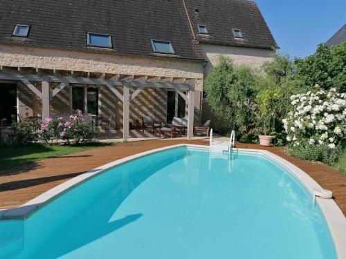 a swimming pool in front of a house at Maison d' hôtes individuelle La Relinquière in Milhac