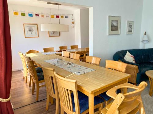 una sala da pranzo con tavolo e sedie in legno di Ferienhaus-Fiete-XXL a Sagard