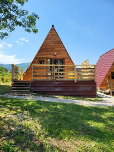 uma grande cabana de madeira com um telhado vermelho em Chalet en A de la Motte-Fanjas 