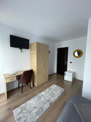 ein Wohnzimmer mit einem Schreibtisch und einem TV in der Unterkunft Vila Hojda in Moisei