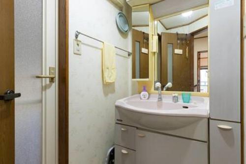 uma casa de banho com um lavatório e um espelho em Noriko's Home - Vacation STAY 13624 em Kawasaki