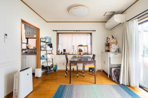 ein Esszimmer mit einem Tisch und einem Fenster in der Unterkunft Noriko's Home - Vacation STAY 13624 in Kawasaki