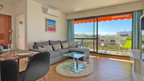 un salon avec un canapé et une table dans l'établissement Le Maxime, à Sainte-Maxime