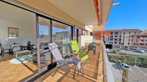 uma varanda com cadeiras, uma mesa e um sofá em Le Maxime em Sainte-Maxime